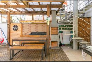 un patio con una mesa de madera y un banco en Villa das Flores - aptos 2 e 9, en Pinheira