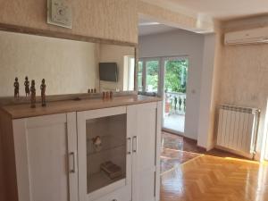 a kitchen with white cabinets and a tv on the wall at Apartment Donna Rijeka in Rijeka