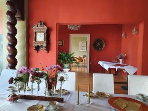 a red room with a table with flowers and a clock at Villa Dorothea in Heringsdorf