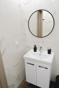 a bathroom with a white sink and a mirror at 71 East Apart Hotel in Prigorodnyy