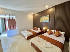 a hotel room with two beds and a window at Hoàng Ngân Hotel Phú Yên in Liên Trì (3)
