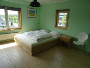 a bedroom with a bed and a chair in it at Kustverhuur, Dorpswoning Breskens, Boulevard 15 in Breskens
