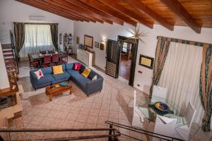 a living room with a blue couch and a table at Villa Gagliardetta in Castellammare del Golfo