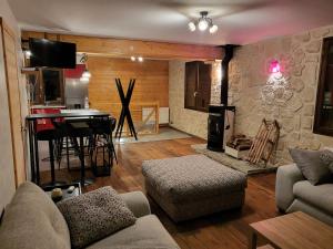 - un salon avec un canapé et une table avec un piano dans l'établissement Maison de moyenne montagne baignée par le soleil, à La Côte-dʼAime