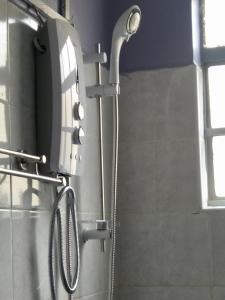 a shower in a bathroom with a shower head at Cozy Rooms -JKIA in Syokimau