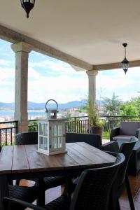 a table with a lantern on a balcony with a view at Altos de Baiona in Baiona