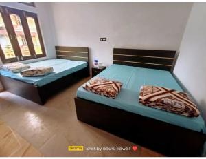 2 camas individuais num quarto com 2 janelas em AK resort, Barkot em Barkot