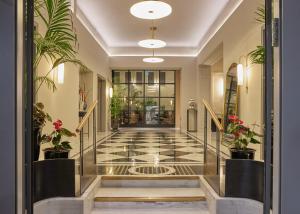 a lobby with a tiled floor and potted plants at Rephael House Boutique Hotel in Rishon LeẔiyyon