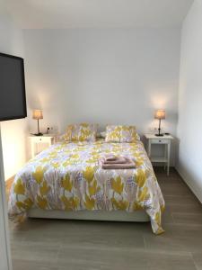 a bedroom with a bed with a yellow and white comforter at Encantadora casa rural Can Vidal in Espolla