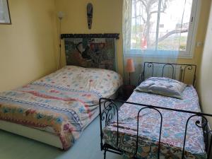 1 dormitorio con 2 camas y ventana en maison piscine, en Dompierre-sur-Mer