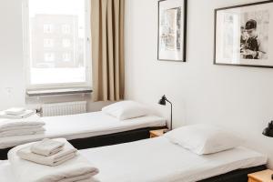 three beds in a room with a window at Norrland YMCA Hostel Umeå in Umeå