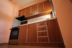 uma cozinha com armários de madeira e um frigorífico em King's Star Hotel em Velipojë