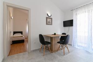 Pokój ze stołem i krzesłami oraz sypialnią w obiekcie Apartments Andrea I w Bašce