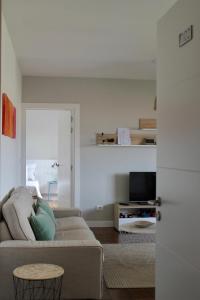 a living room with a couch and a tv at Altos de Baiona in Baiona