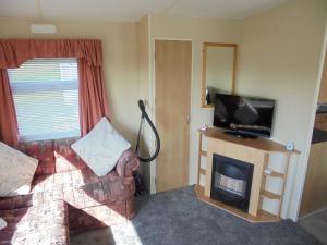 a living room with a couch and a fireplace at 6 Berth heated on The Chase (Albany II) in Skegness
