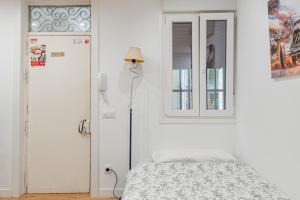 マドリードにあるBuenavistaの白いベッドルーム(ベッド1台、窓付)