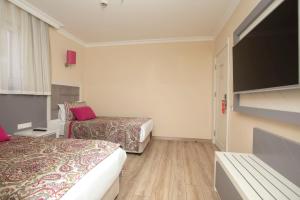 a hotel room with two beds and a flat screen tv at Orange County Belek in Belek