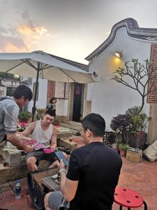 a group of people sitting under an umbrella at Sunny's Home in Jincheng