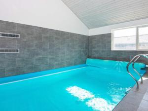 uma piscina com água azul num quarto em 16 person holiday home in R m em Rømø Kirkeby