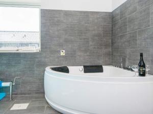 uma banheira branca na casa de banho com uma janela em 16 person holiday home in R m em Rømø Kirkeby