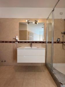 un bagno con un lavandino bianco e uno specchio di Appartamenti Baia Azzurra 4. a Torbole