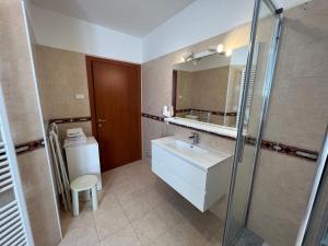 a bathroom with a sink and a mirror at Appartamenti Baia Azzurra 4. in Nago-Torbole
