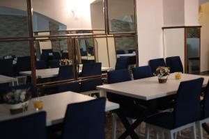 a dining room with tables and blue chairs at Hotel Casa Italia in Calafat