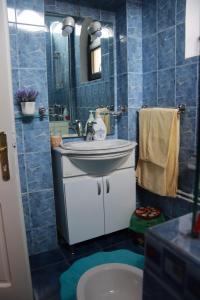 Baño de azulejos azules con lavabo y espejo en Hotel Casa Italia en Calafat