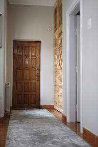 un pasillo vacío con una puerta de madera y una alfombra en Hotel Casa Italia en Calafat
