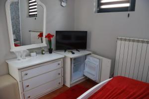 a bedroom with a tv and a dresser with a dresserngth at Hotel Casa Italia in Calafat