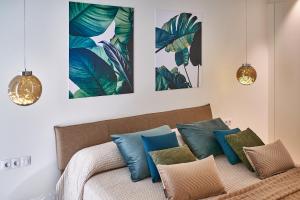 una camera da letto con un letto con cuscini blu e verdi di Luxury Villa in Abama a Guía de Isora