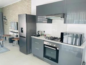 a kitchen with a stove and a refrigerator at Ultra modern 2 bedroomed apartment - 2082 in Bulawayo