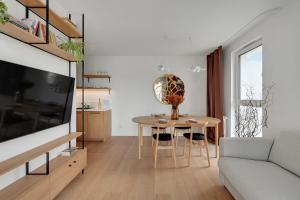 een woonkamer met een tafel en een bank bij Boutique Aura 40 by Grand Apartments in Gdańsk