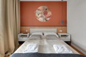 a bedroom with a large bed and a painting on the wall at Boutique Aura 40 by Grand Apartments in Gdańsk