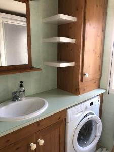 a bathroom with a sink and a washing machine at Mobile Home, Camping Le Dattier, Fréjus, South of France in Fréjus