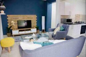uma sala de estar com um sofá e uma televisão em Mellow 2 bedroomed cottage - 2083 em Bulawayo