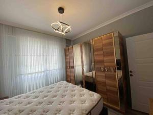 Schlafzimmer mit einem Bett und einem Holzschrank in der Unterkunft Parpali Rezidans in Ardeşen