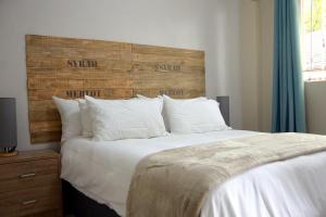 um quarto com uma cama grande e uma cabeceira em madeira em Mellow 2 bedroomed cottage - 2083 em Bulawayo