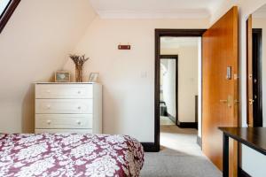 een slaapkamer met een bed, een dressoir en een spiegel bij Double room 2 mins from station in Belvedere