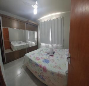 a bedroom with a large bed and a mirror at Condominio dos Lagos I in Capitólio