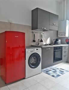 una cucina con lavatrice e frigorifero rosso di La Nchioscia a La Spezia