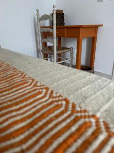 梅里戴斯的住宿－À Espera - Turismo Rural,Melides，一间卧室配有一张床、一张桌子和一把椅子