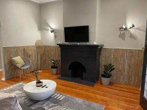 sala de estar con chimenea y TV de pantalla plana en Modern Apartment - 2081, en Bulawayo