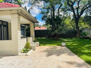 a house with a brick driveway in front of a yard at Modern Apartment - 2081 in Bulawayo
