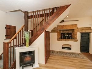 a living room with a fireplace and a staircase at The Old Bakery in Beaminster