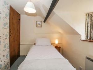 um pequeno quarto com uma cama no sótão em The Old Bakery em Beaminster