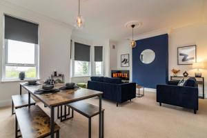a living room with a table and a blue wall at 3 bed house sleeps 6 walking distance in to Nottingham city centre ideal for contractors and corporate travellers in Nottingham