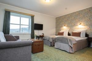 Un pat sau paturi într-o cameră la Kronen Gaard Hotel