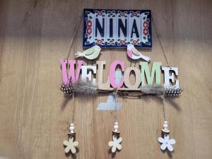 a wooden sign that says nina wet zone and flowers at Apartament Nina in Jelenia Góra