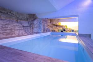 una gran piscina con una pared de piedra en SOWELL RESIDENCES New Chastillon, en Isola 2000